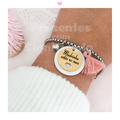 Pulseira com pendente de madeira e tassel rosa no pulso