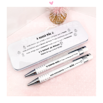 Estojo metálico branco com texto sobre a mãe e duas canetas brancas sobre fundo rosa