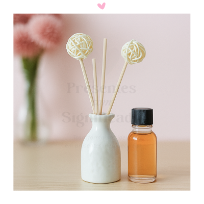 Conjunto aromatizador com garrafa de cerâmica branca e frasco com líquido âmbar