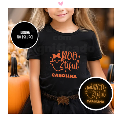 T-shirt preta infantil estampada com fantasma e texto laranja que brilha no escuro, foto com abóboras ao fundo