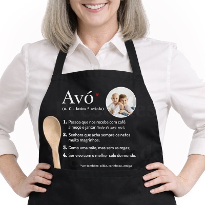 Avental preto com texto sobre avó e foto de crianças, usado por pessoa com camisa branca.