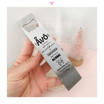 Abridor de garrafas metálico com texto em português e fundo rosa com decoração natalícia