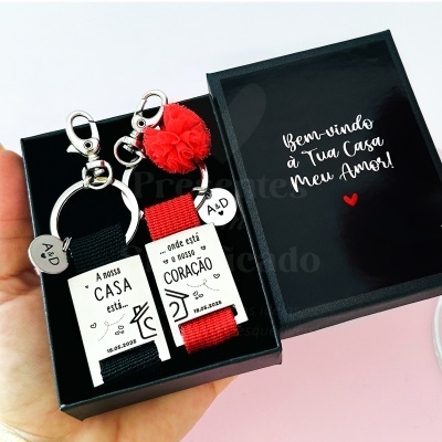 Chaveiros com mensagens de amor e data numa caixa preta com mensagem de boas-vindas