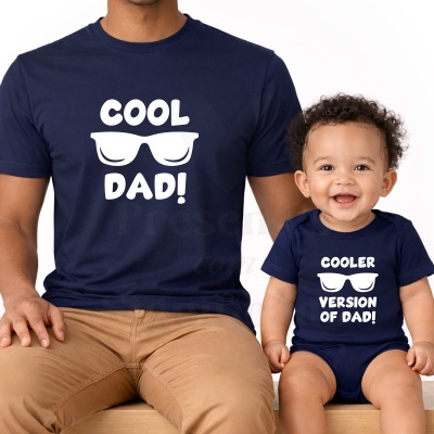 T-shirt azul escura para adulto e body azul escuro para bebé com textos e óculos de sol brancos.