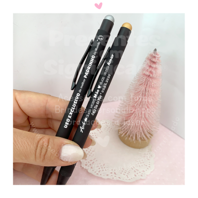 Dois lápis de madeira pretos com ponteiras em borracha e texto branco, junto de uma árvore rosa pequena sobre fundo rosa.