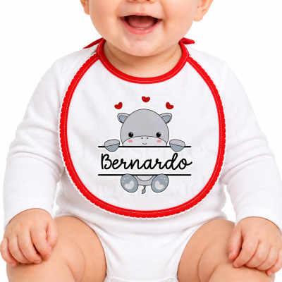 Babete branco com borda vermelha e desenho de hipopótamo com nome Bernardo.
