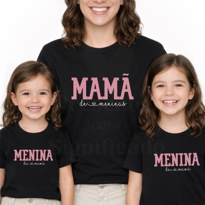 T-shirts pretas com texto rosa e branco, mãe com duas filhas sorrindo.