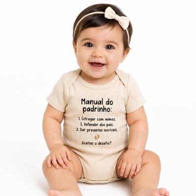 Bebé vestido com body bege com texto e fita de cabeça com laço bege.