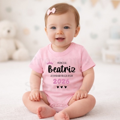 Bebé com body rosa personalizado sentado num tapete branco