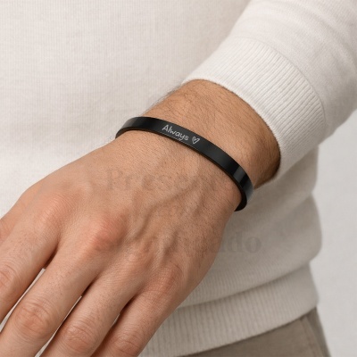 Pulseira preta de metal com inscrição Always no pulso de uma pessoa