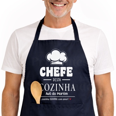 Avental azul escuro com texto branco e vermelho e colher de madeira no bolso