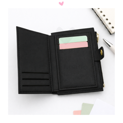 Carteira preta aberta com divisórias para cartões sobre superfície branca