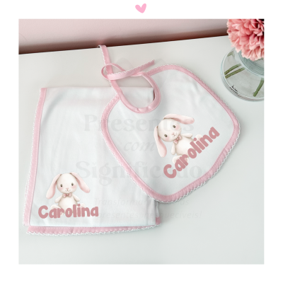 Babete e toalha brancos com bordas cor-de-rosa e coelho rosa com o nome Carolina