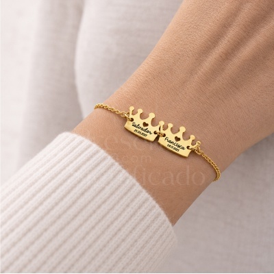 Pulseira dourada com coroas personalizadas com nomes e datas.