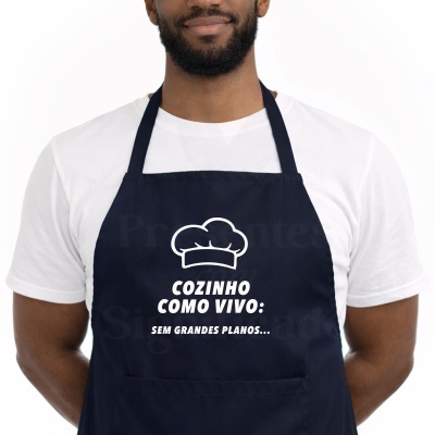 Avental azul escuro com texto e gráfico em branco usado por pessoa com t-shirt branca