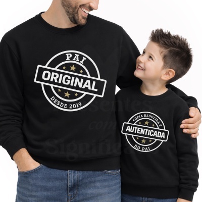 Pai e filho com sweatshirts pretas com estampas PAI ORIGINAL DESDE 2019 e CÓPIA REDUZIDA E AUTENTICADA DO PAI.