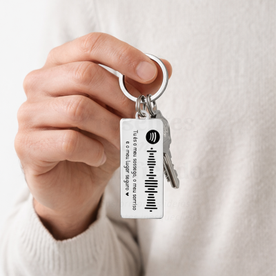 Porta-chaves metálico prateado com placa branca e texto em português