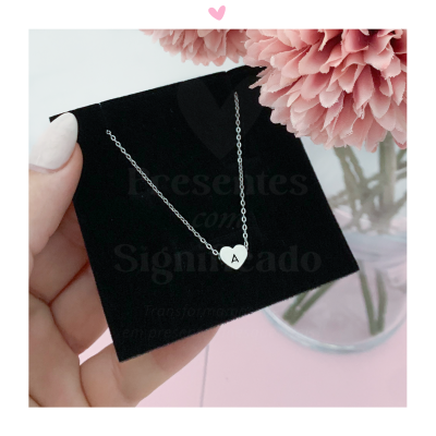 Colar com pendente em forma de coração com letra A em cartão preto e flor rosa ao lado