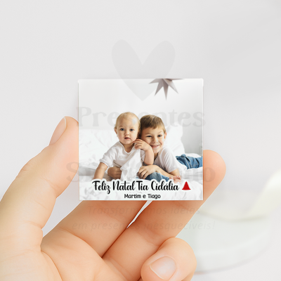 Fotografia quadrada de duas crianças numa cama branca com texto de Natal personalizado.