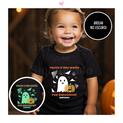 Criança sorridente usando camisa preta com estampa luminosa de fantasma e abóbora, texto alusivo a troca do irmão por rebuçados.