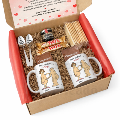 Caixa de presente com canecas, cappuccino, bolachas, Twix, doce de morango e colheres com texto romântico.