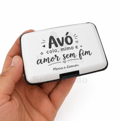 Estojo branco com texto personalizado para avó, segurado por uma mão.