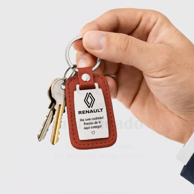 Chaveiro de couro castanho com placa metálica branca e texto da Renault