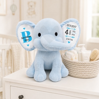 Elefante de peluche azul com bordados e cesta de produtos para bebé num ambiente de quarto