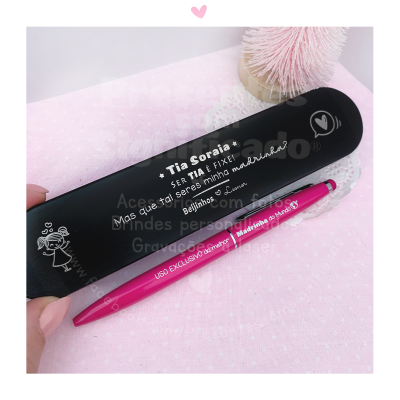 Estojo escolar preto com texto e caneta rosa sobre fundo cor-de-rosa pontilhado