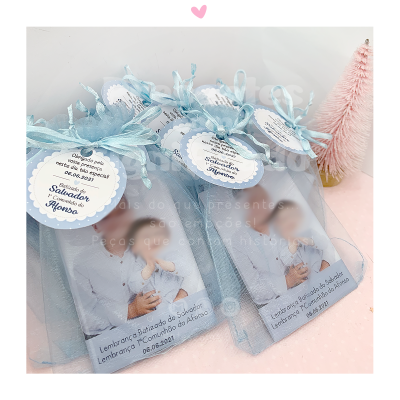 Pacotes de lembranças para batizado com fita azul e etiqueta personalizada.