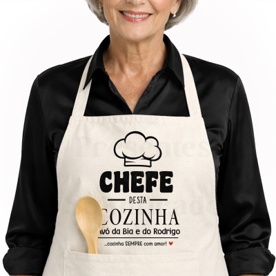 Avental de tecido bege com texto e desenho preto e vermelho usado por pessoa com camisa preta