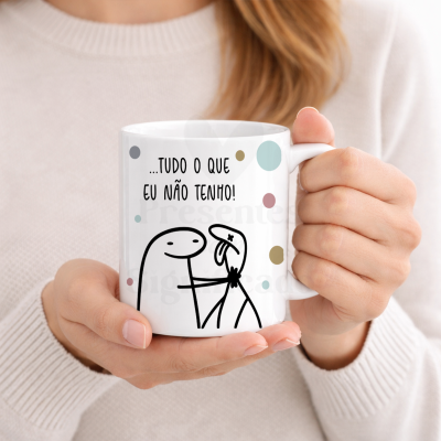 Caneca branca com ilustração e texto em português, segurada por mãos femininas.