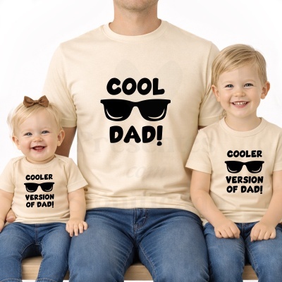 Pai e dois filhos com t-shirts bege, texto preto e óculos de sol desenhados.