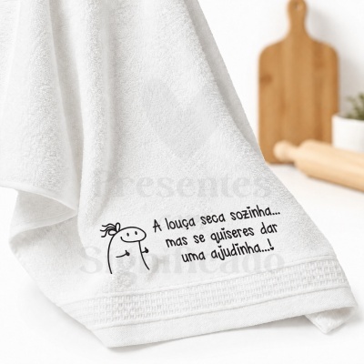 Toalha branca com texto humorístico e desenho simples, em ambiente de cozinha