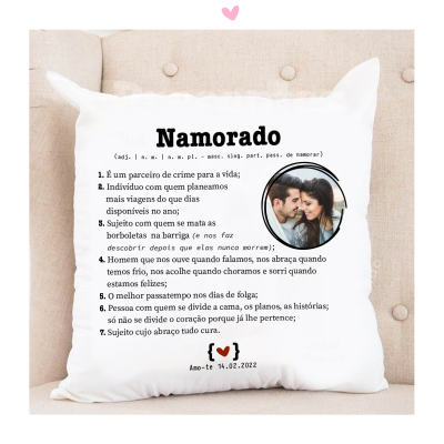 Almofada branca com texto e imagem decorativa de casal, colocada num sofá bege