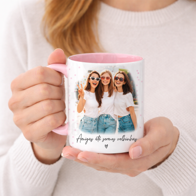Caneca branca com interior cor-de-rosa, fotografia de três amigas e texto Amigas até sermos velhinhas.