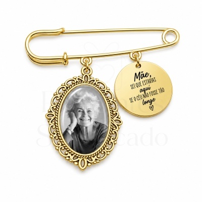 Alfinete de segurança dourado com foto de senhora e pendente com mensagem em português