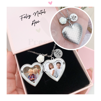 Colar prateado em forma de coração com pichações e pendentes, dentro de caixa rosa com interior preto