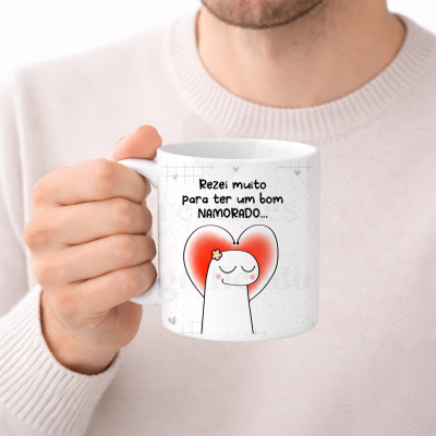 Caneca branca com desenho cartoon e texto em português segurada por uma mão.