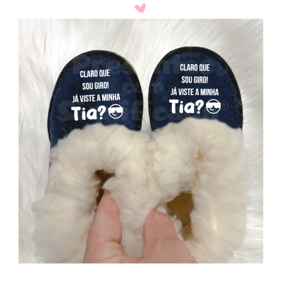 Chinelos azuis com pelo branco e texto divertido numa superfície branca felpuda