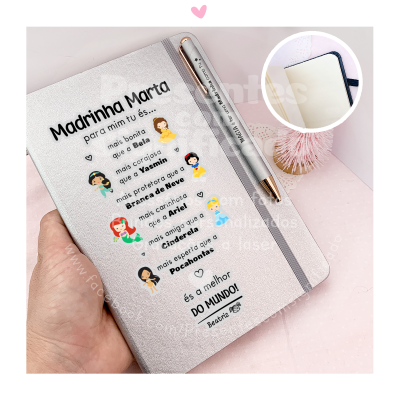 Caderno personalizado com texto e ícones de princesas, caneta prateada, fundo rosa.