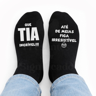 Meias pretas com textos brancos e emoji sorridente usadas com calças de ganga azuis