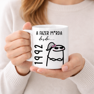 Caneca branca com texto e desenho de personagem, segurada por duas mãos femininas