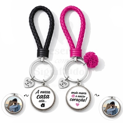 Conjunto de dois porta-chaves em couro trançado preto e rosa com pendentes metálicos redondos e coração com texto.