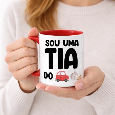 Caneca branca e vermelha com texto e ilustrações, segurada por mãos.