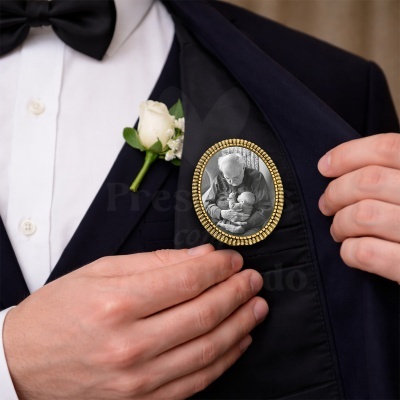 Broche oval dourado com fotografia preto e branco num fato azul escuro