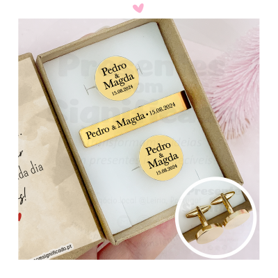 Conjunto de clipe de gravata e botões de punho dourados gravados com nomes e data numa caixa de cartão