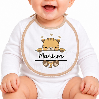 Babete branco com desenho de gatinho castanho e nome Martim no centro, usado por bebé.
