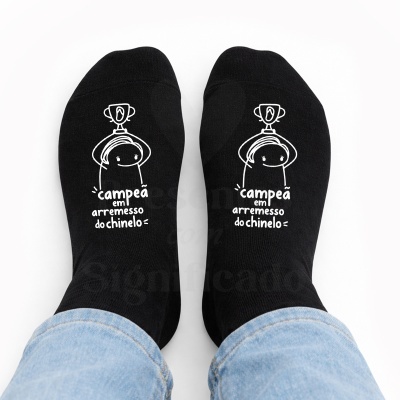 Meias pretas com desenho e texto em branco sobre fundo branco, vista de cima.