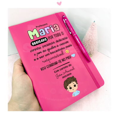 Caderno rosa personalizado para professora com caneta e pequeno ornamento cor-de-rosa.